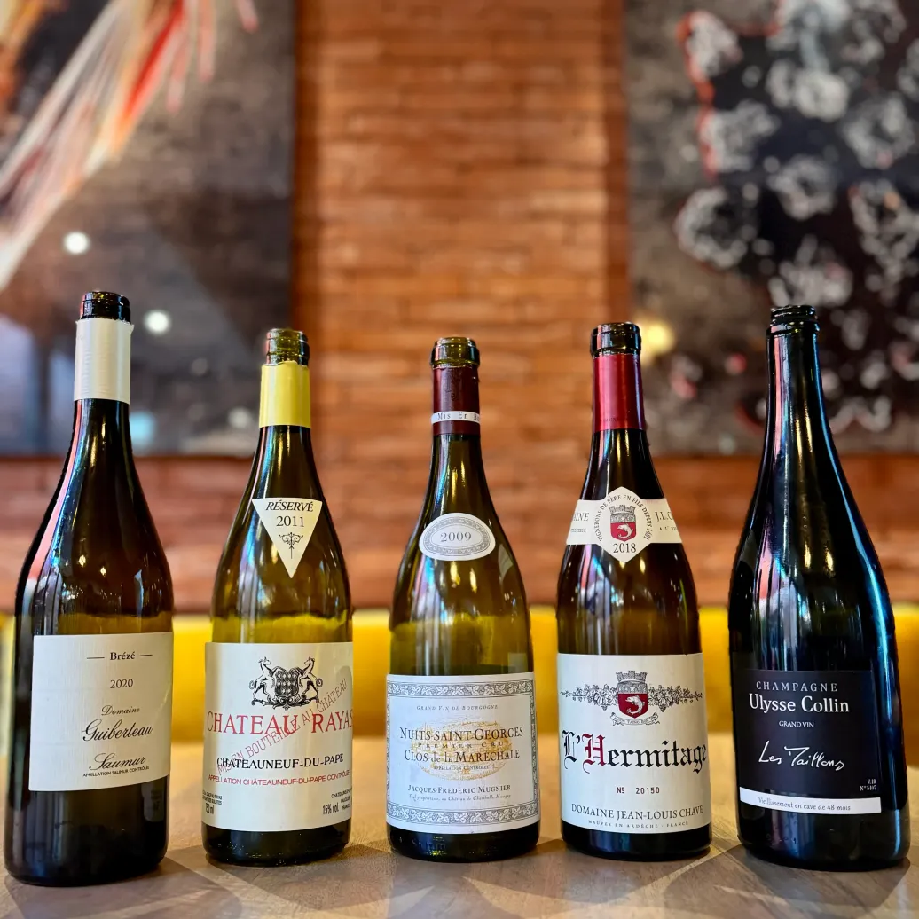 cinq bouteilles de vins alignées